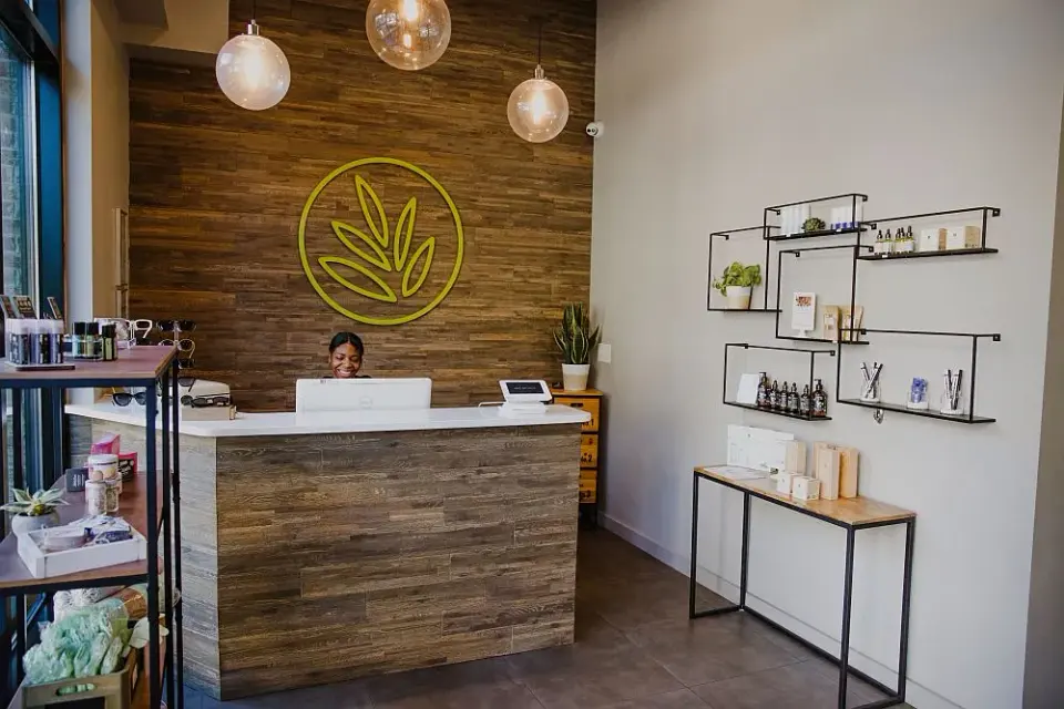 Front desk at Art Of Wax Atlanta with staff member and retail shelving