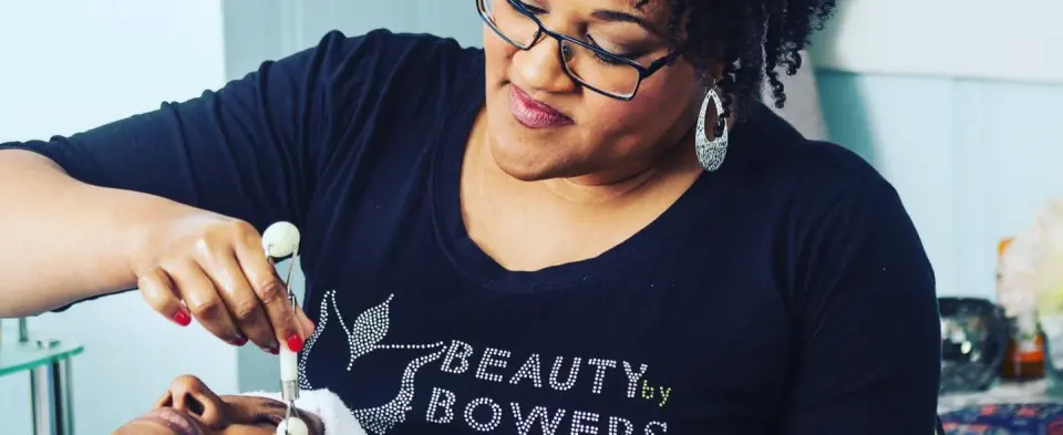 Esthetician at Beauty By Bowers Day Spa, Tucker, wearing a branded shirt during a treatment