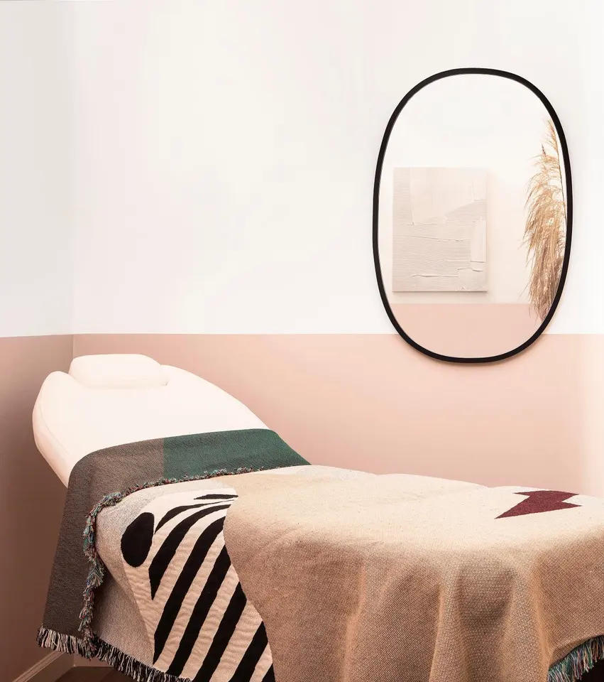 Treatment bed and oval mirror in Cheeks + Co’s Pasadena studio