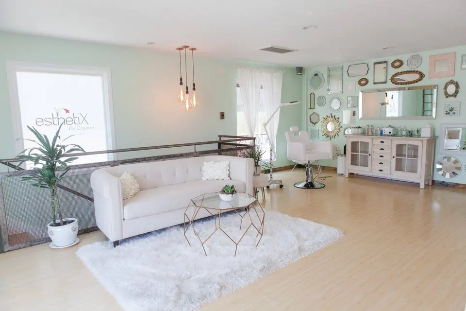 EsthetiX Venice studio with a white sofa, treatment chair and a wall of mirrors