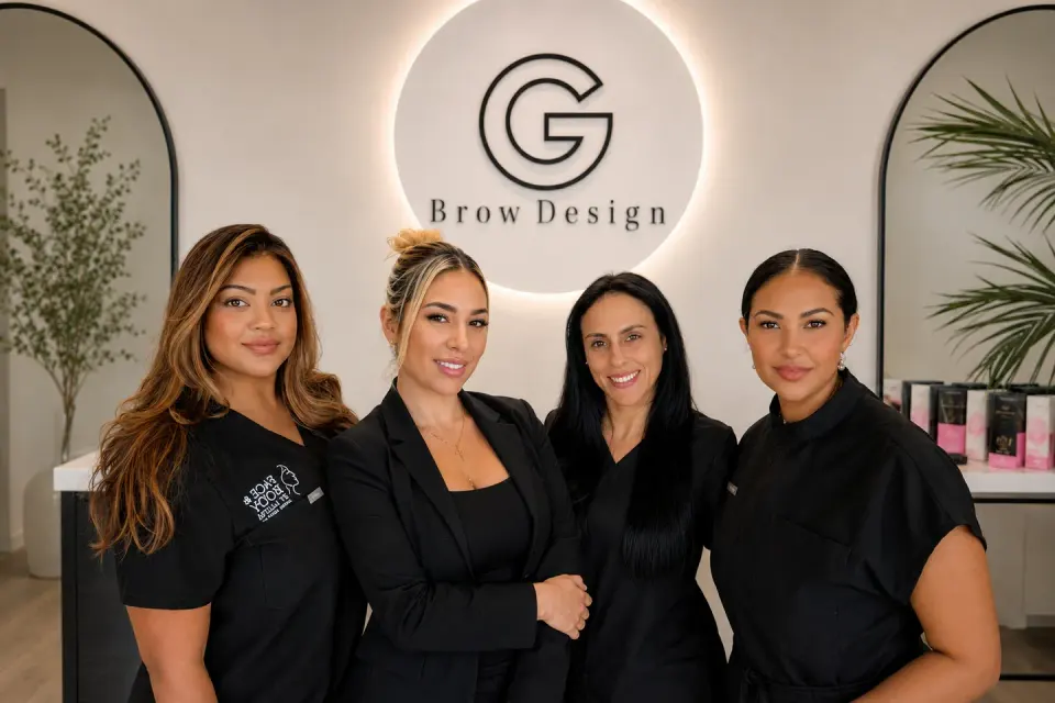 The G Brow Design team in front of their branded lobby sign, Palmetto Bay