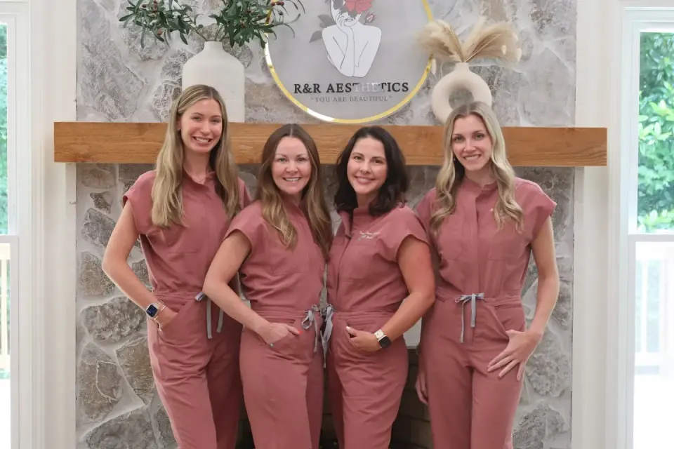 Team at Radiant and Renewed Aesthetics, Roswell, in front of their branded sign