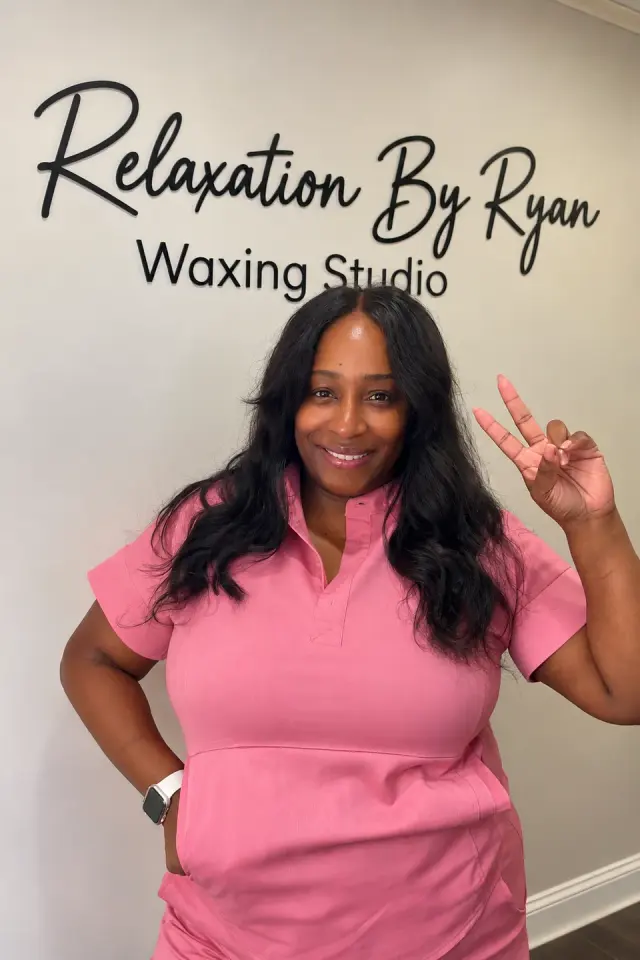 Ryan, owner of Relaxation By Ryan Waxing Studio, in front of the studio sign, Roswell
