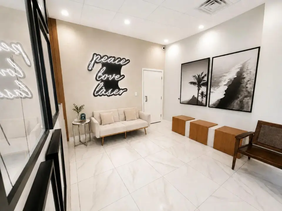 Waiting lobby with "Peace Love Laser" neon sign at Semper Laser, Doral