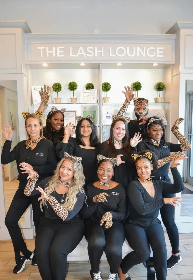 Staff team at The Lash Lounge Pembroke Pines, in front of the branded reception desk