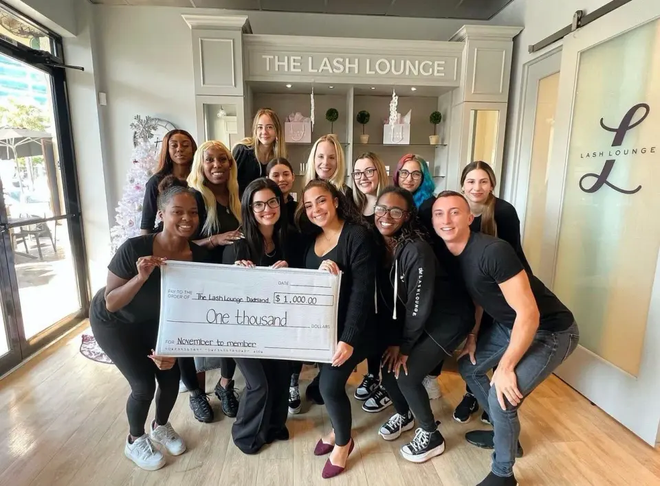 Staff team at The Lash Lounge Dadeland, in front of the branded reception desk