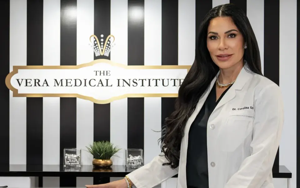 Dr. Carolina Vera beside The Vera Medical Institute reception sign, Plantation