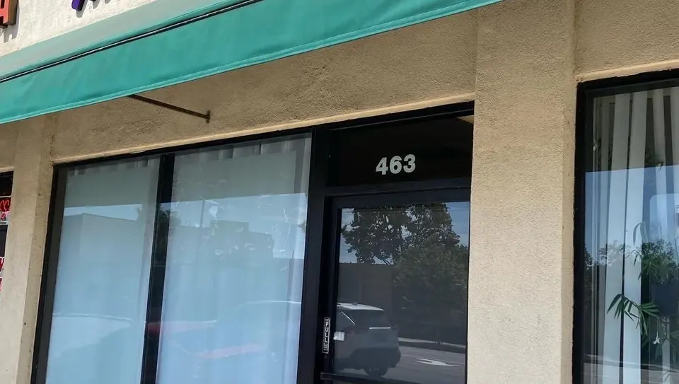 Thee V Suite storefront with teal awning and door number 463